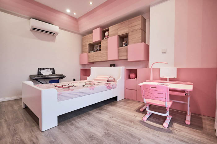 Một chiếc giường nhỏ kết hợp với bàn học cùng màu hồng với cả phòng
